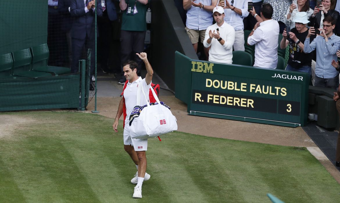 Roger Federer acena para torcedores ao deixar a quadra após ser derrotado pelo polonês Hubert Hurkacz nas quartas de final em Wimbledon