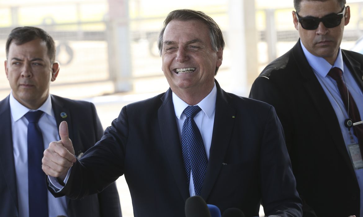 O presidente Jair Bolsonaro, cumprimenta populares no Palácio da Alvorada