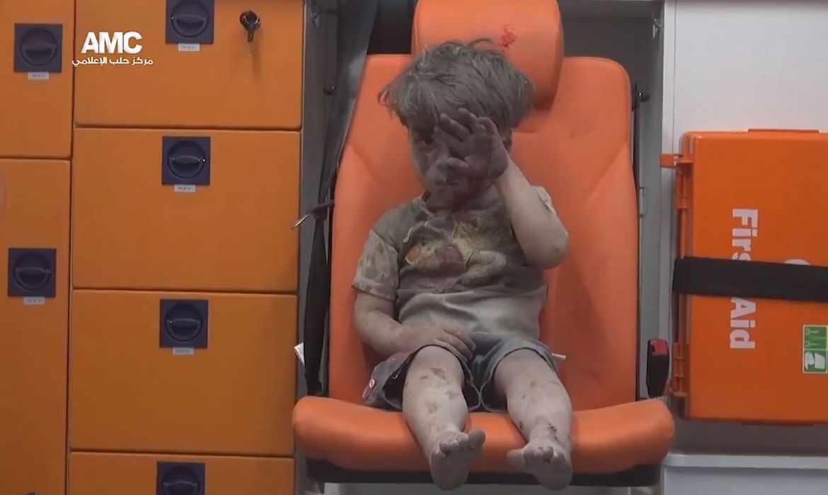 Ativistas do grupo Aleppo Media Center (AMC) divulgaram a imagem do menino Omar Daqneesh, de 5 anos, logo após ser resgatado de um bombardeio na cidade de Aleppo, na Síria