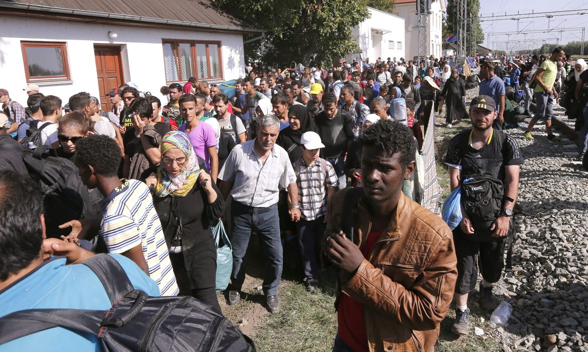 Migrantes que cruzaram fronteira da Sérvia com a Croácia aguardam em campo para fazer registro