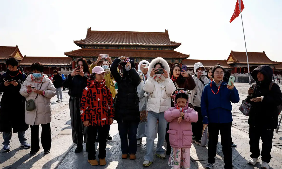 Turistas tiram fotos em Pequim
 21/2/2025   REUTERS/Tingshu Wang