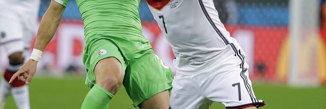 O jogador alemão Bastian Schweinsteiger disputa lance com o argelino Mehdi Mostefa