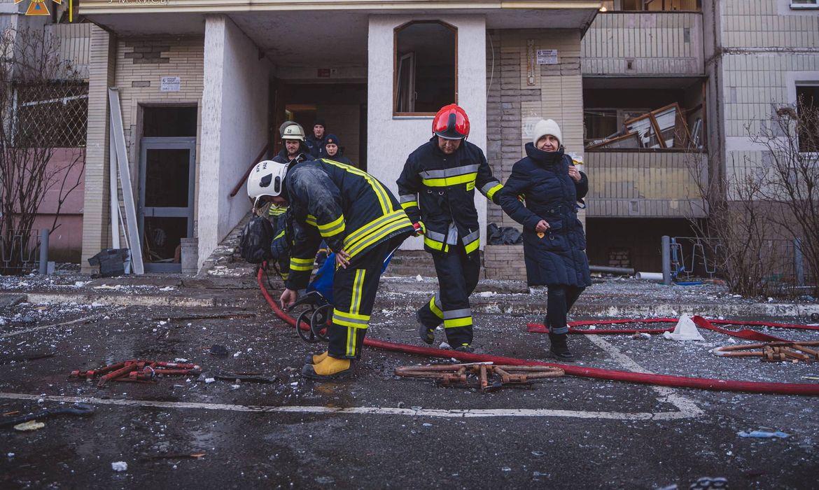 Equipes de resgate ajudam mulher a sair de prédio residencial atingido por ataque aéreo em Kiev