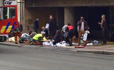 Equipes de emergência socorrem feridos em frente à estação Maelbeek do metrô, em Bruxelas. Explosões fizeram o governo fechar todos os serviços de metrô da cidade. Outras explosões no aeroporto da capital deixaram 13 mortos