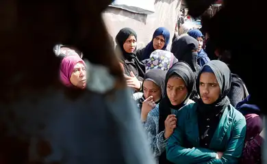 Palestinians gather to receive bread from a bakery, in Khan Younis, in the southern Gaza Strip, March 9, 2025. Reuters/Hatem Khaled/Proibida reprodução