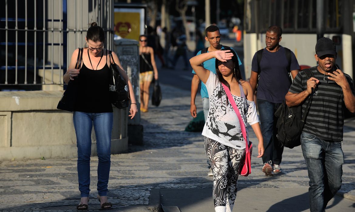 Pedestres se protegem do sol na região da Central do Brasil durante onda de calor que atinge a cidade do Rio de Janeiro nos últimos dias de inverno (Fernando Frazão/Agência Brasil)