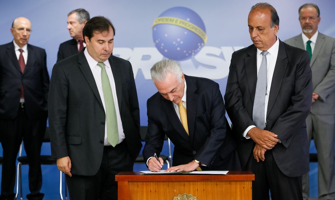 Presidente Michel Temer assina o decreto de intervenção federal no estado do Rio de Janeiro, ao lado do presidente da Câmara, Rodrigo Maia, e do governador do estado, Luiz Fernando Pezão 

