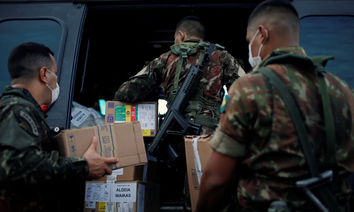 Militares das Forças Armadas descarregam suprimentos de helicóptero em Boa Vista, Roraima