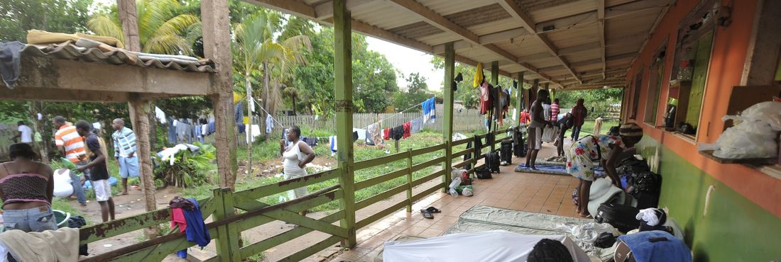 Cerca de 200 haitianos aguardam visto provisório para trabalhar no país. Eles vivem em condições precárias e se alimentam de doações.