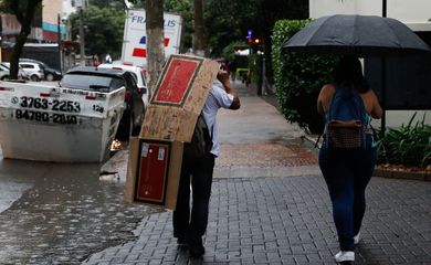 São Paulo (SP),14/03/2023 - Pessoas se protegem da chuva que deixa São Paulo em estado de atenção no final da tarde, na Rua Carlos Weber. Foto: Fernando Frazão/Agência Brasil