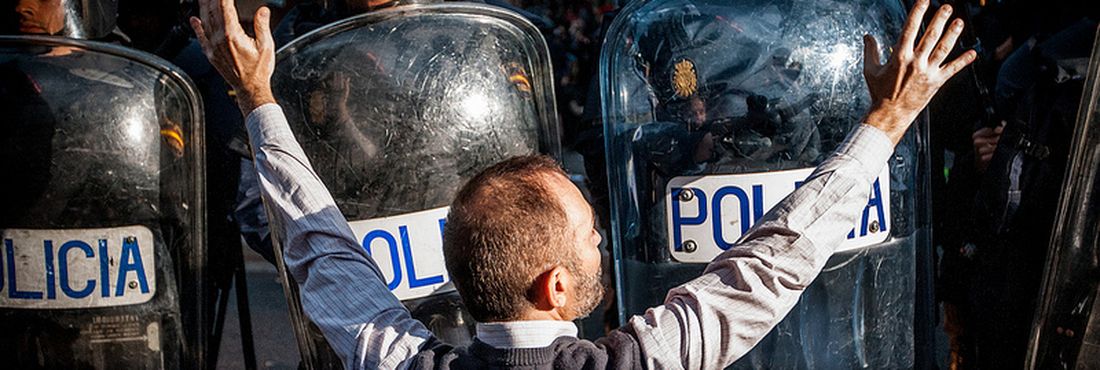 Manifestante em frente a barreira de policiais durante prostesto na Espanha