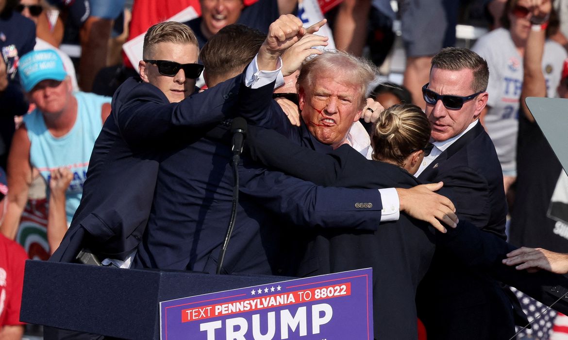 Pensilvânia. 14/07/2024 O candidato presidencial republicano e ex-presidente dos EUA, Donald Trump, é auxiliado por pessoal de segurança após o tiroteio durante um comício de campanha no Butler Farm Show em Butler, Pensilvânia, EUA.  Crédito/REUTERS