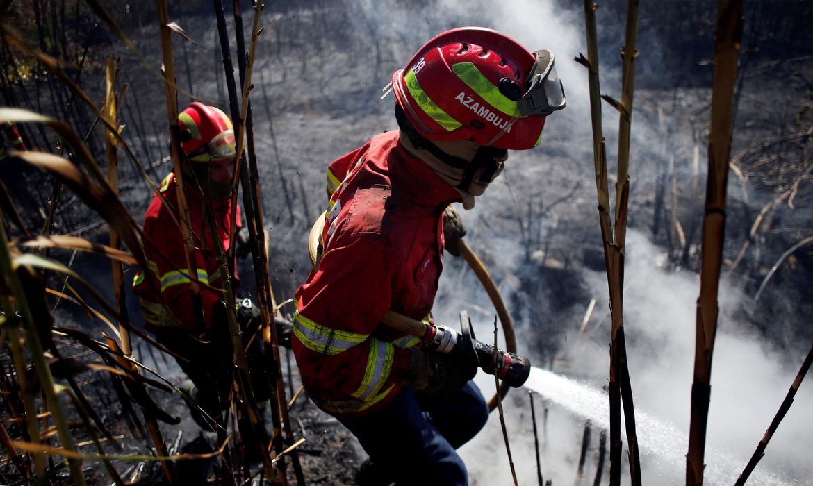REUTERS/Pedro Nunes/Direitos reservados Bombeiros trabalham no rescaldo do incĂȘndio na Serra de Sintra em Cascais, Portugal