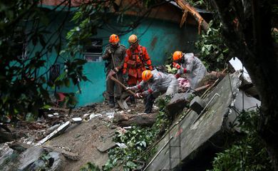 Bombeiros trabalham no local de um deslizamento de terra após uma forte chuva na favela Babilônia, no Rio de Janeiro