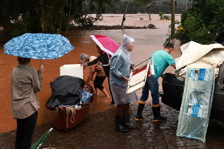 People rescue their belongings near a flooded area next to the Taquari River during heavy rains in the city of Encantado in Rio Grande do Sul, Brazil, May 1, 2024. REUTERS/Diego Vara