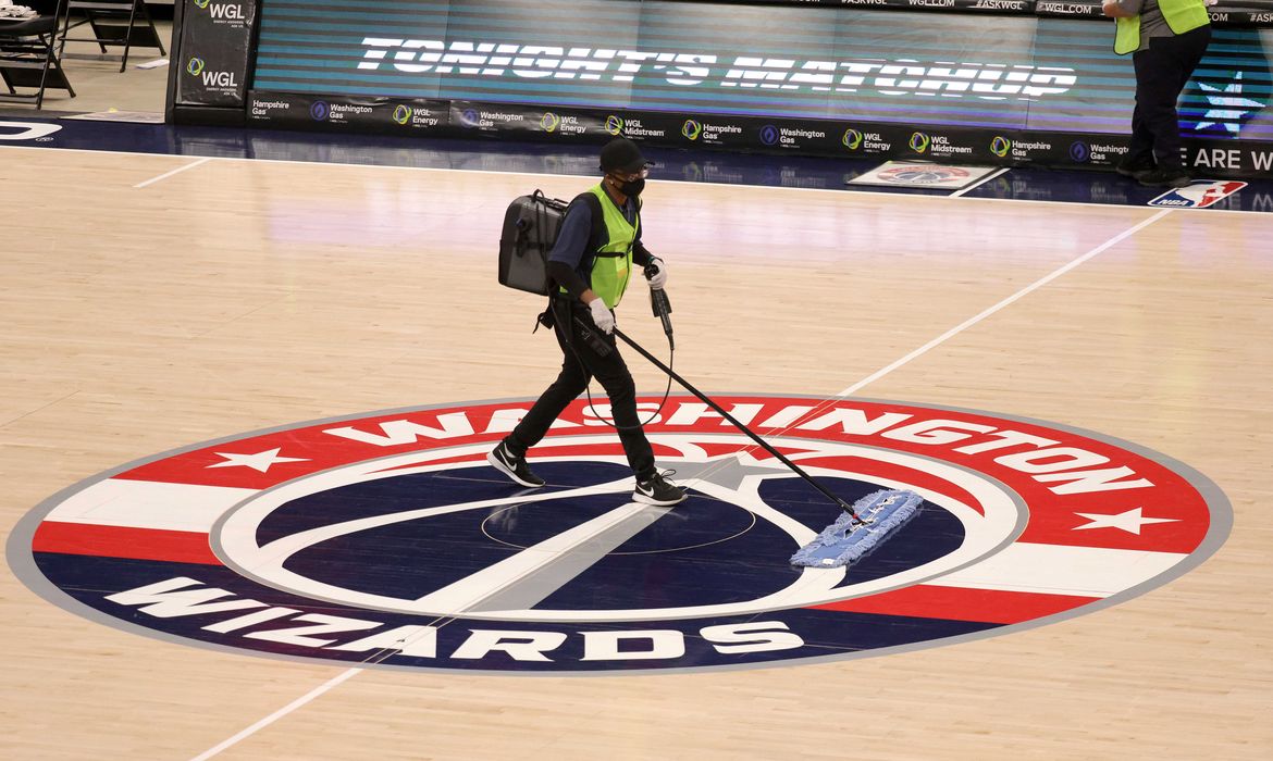 Funcionário limpa o piso da quadra da Capital One Arena, em Washington, para jogo da NBA