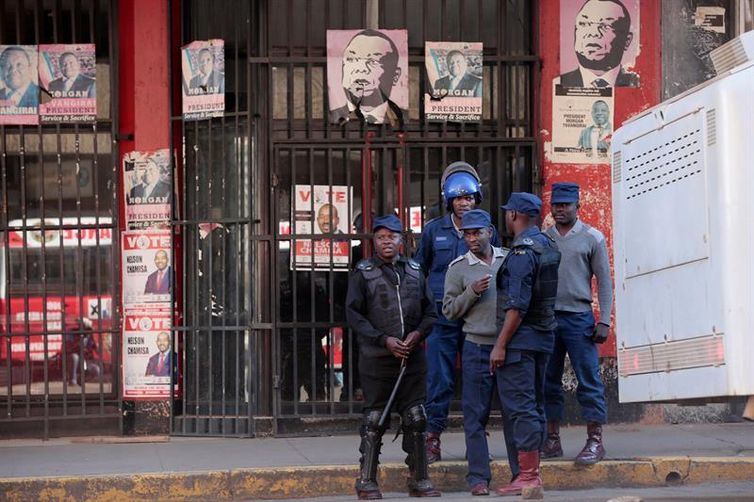 Policiais em frente à sede do partido de oposição Movimento pela Mudança Democrática (MDC) en Harare 