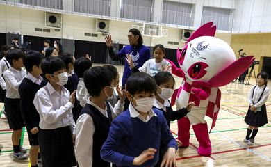 Crianças usando máscara de proteção de coronavírus brincam com mascote dos Jogos ParalímpicosParalympic Games in