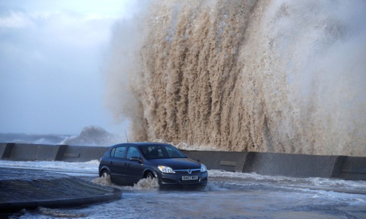 Carro passa por estrada alagada pela tempestade Eleanor em New Brighton, no Reino Unido 