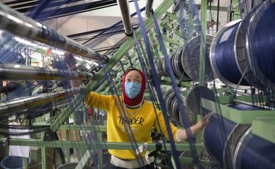 Funcionário de fábrica chinesa trabalha com máscara de proteção