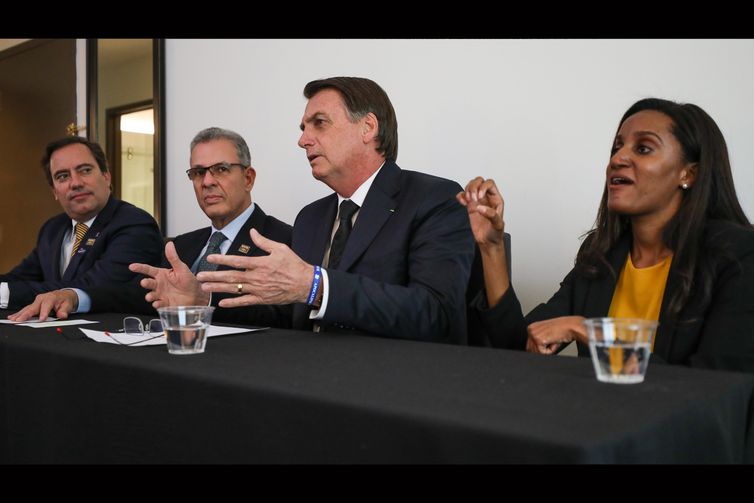 O presidente Jair Bolsonaro, em Dallas (EUA), faz transmissão ao vivo para as redes sociais. ao lado do presidente da Caixa, Pedro Guimarães, do ministro de Minas e Energia, Bento Albuquerque, e da intérprete de libras, Joyce Porto.