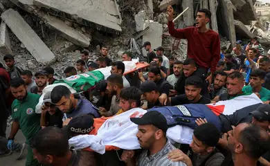 A flak jacket and a Palestinian flag are placed on the body of Al Jazeera journalist Anas Al Sharif, during the funeral for him, Mohammed Qreiqeh, Ibrahim Zaher, Mohammed Noufal and another colleague, who were killed in an Israeli strike, in Gaza City August 11, 2025. REUTERS/Dawoud Abu Alkas     TPX IMAGES OF THE DAY