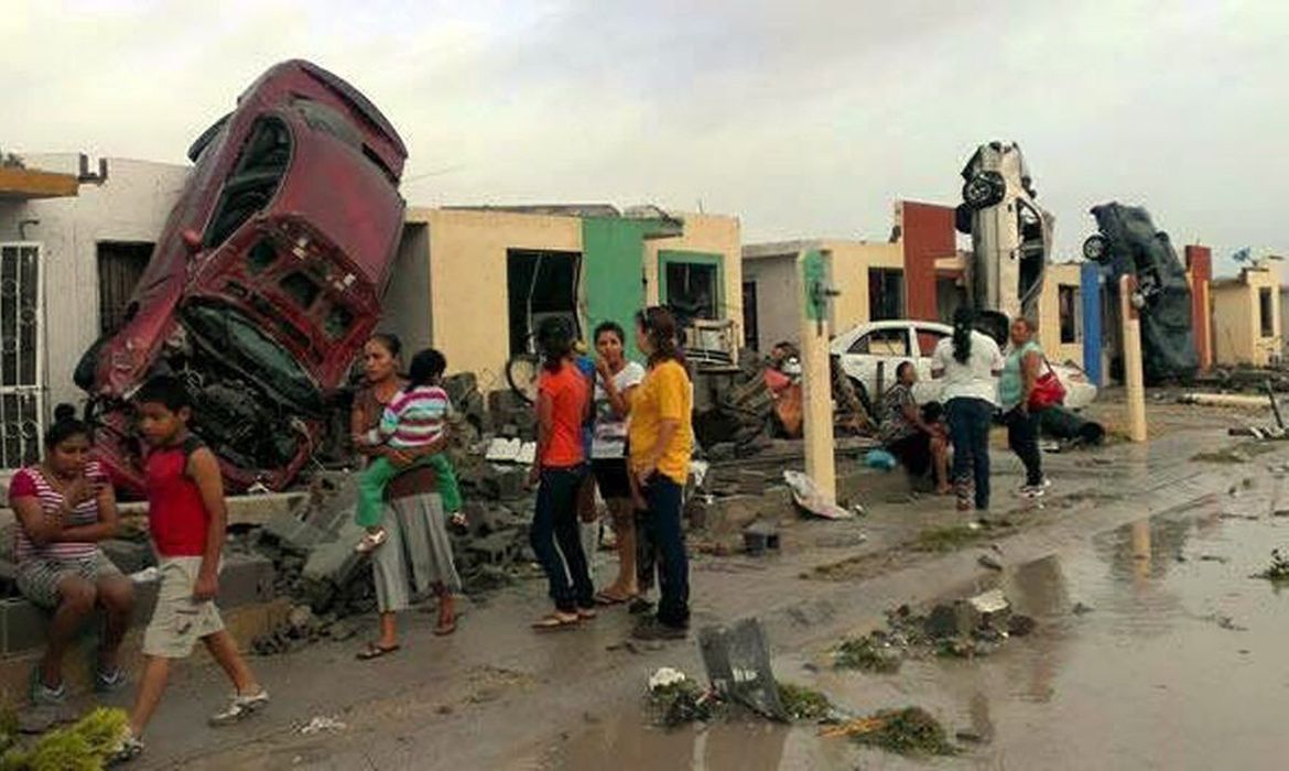 Moradores observam os estragos provocados pela passagem de um tornado na Ciudad Acuña, Norte do México