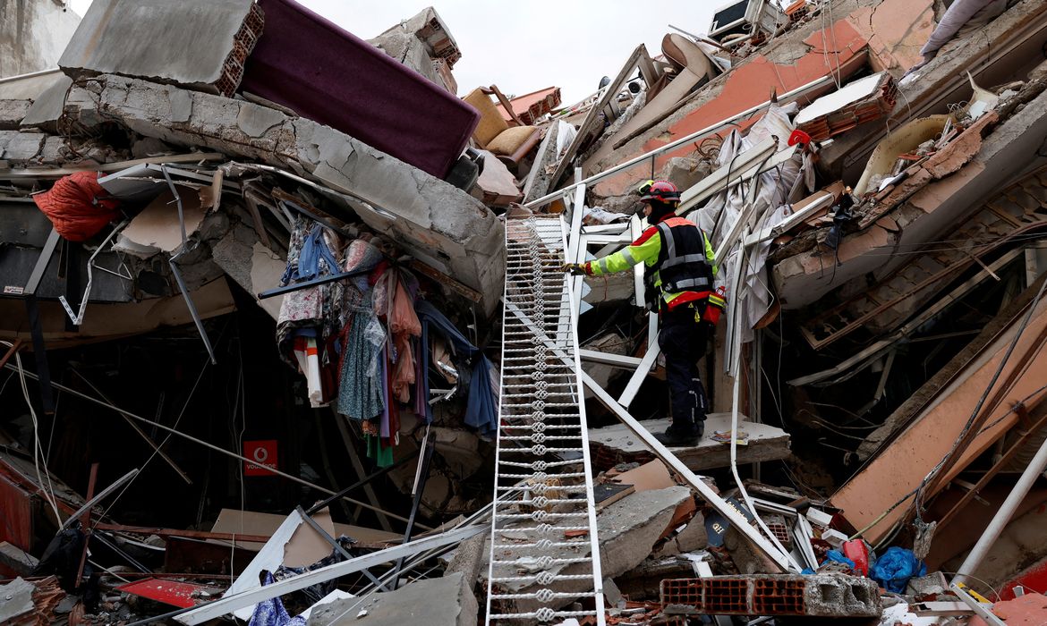 Agente de resgate nos destroços de prédio destruído por terremoto em Kirikhan, na Turquia