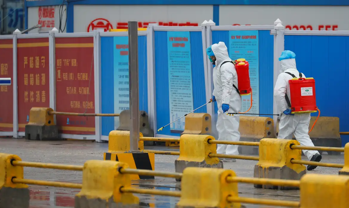 Trabalhadores lançam desinfetante em mercado de Wuhan durante visita da OMS