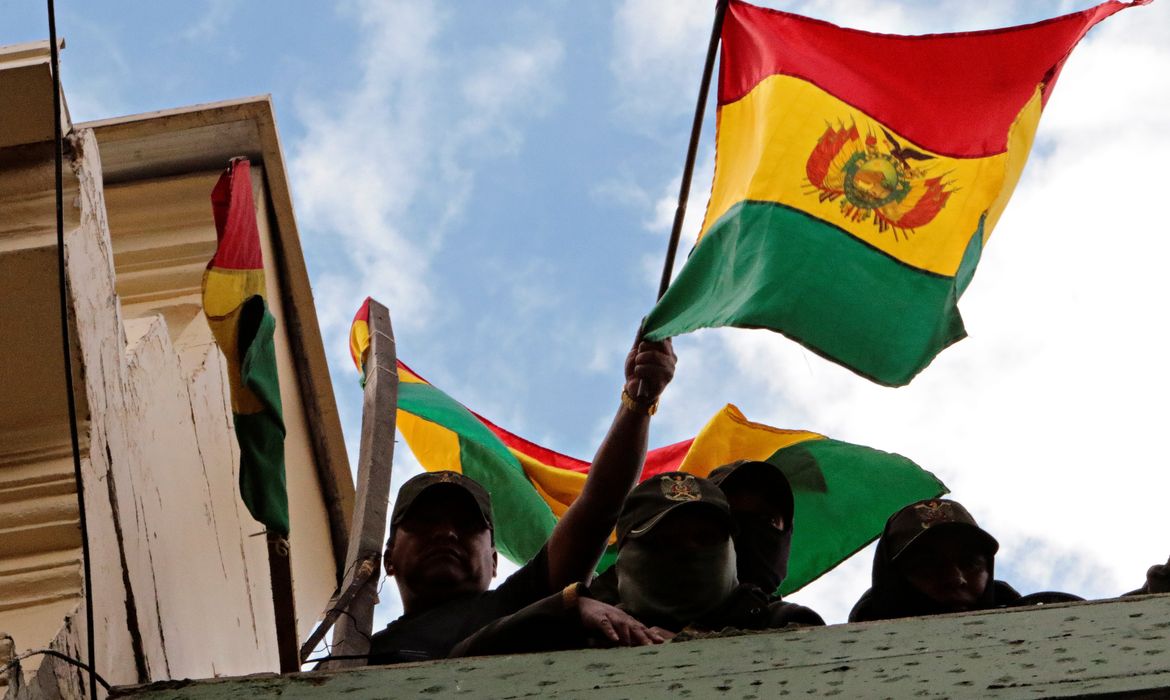 Police officers hold up Bolivian flags while delivering a statement on the roof of a police station during a protest against Bolivia's President Evo Morales in La Paz, Bolivia, November 9, 2019. REUTERS/Manuel Claure NO RESALES. NO ARCHIVES