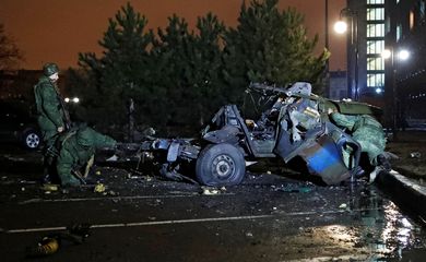 Specialists inspect a wreckage of a car that according to the local authorities was blown up in Donetsk