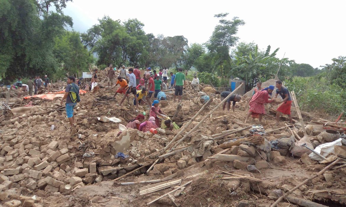 Nepaleses vítimas de inundações buscam seus pertences depois que a chuva destruiu casas em Motipur, no distrito Dang