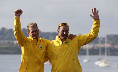 Bronze medallists Brazil's skipper Robert Scheidt and crew Bruno Prada wave during their men's star class keelboat sailing medal race victory ceremony at the London 2012 Olympic Games in Weymouth and Portland