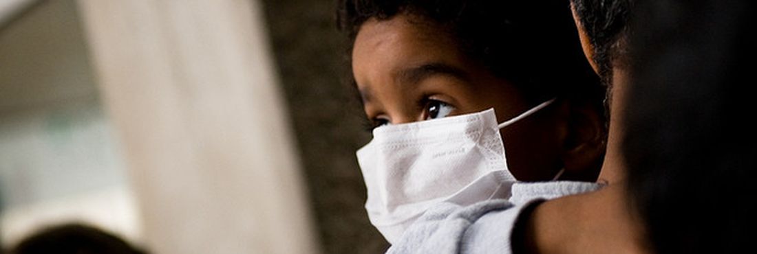Criança usa máscara para se proteger do vírus da gripe A (gripe suína)