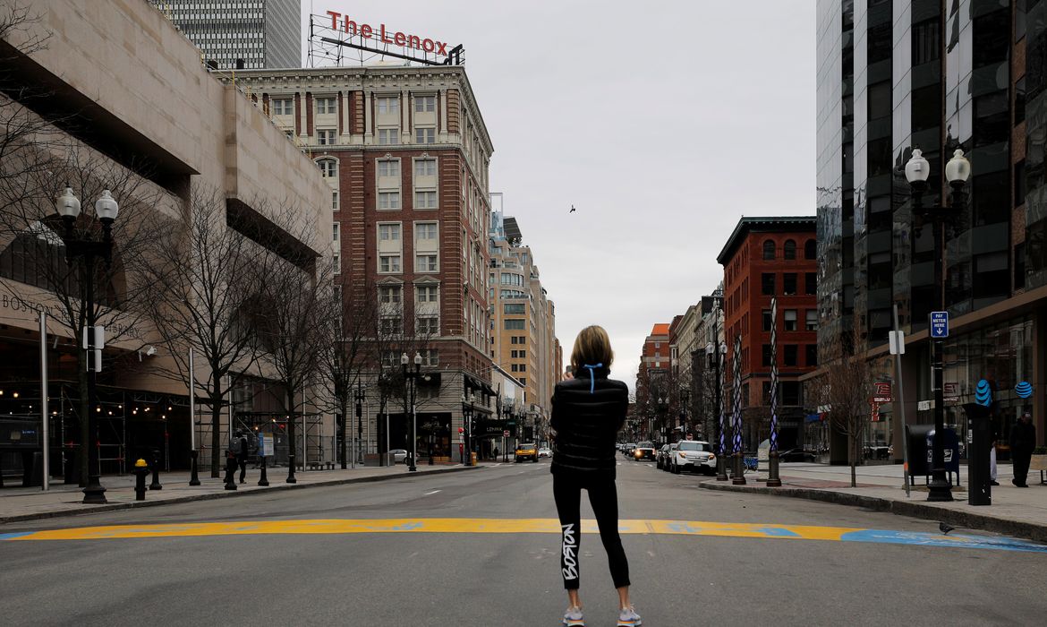 Mulher tira foto no local da chegada da Maratona de Boston