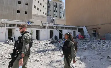 Members of the Israeli security forces walk near the Soroka Medical Center, the city's general hospital, at an impact site following a missile strike from Iran on Israel, in Beersheba, Israel on 19 June 2025.    Marc Israel Sellem/Pool via REUTERS
