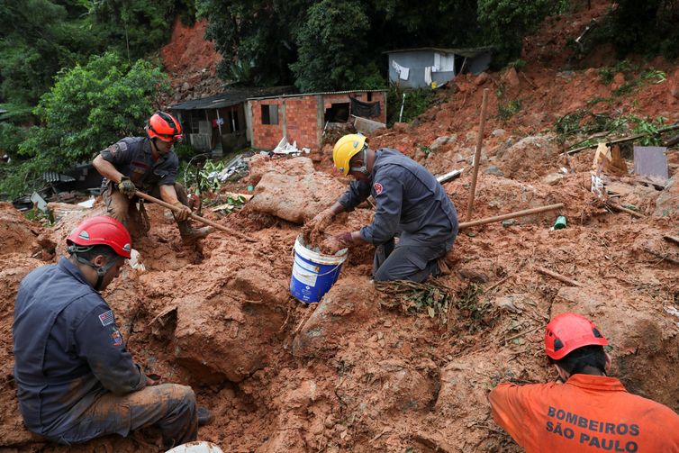 Firefighters dig for victims of a mudslide, where five people died and four remain missing according to the fire department, in Morro do Macaco Molhado (wet monkey hill) in Guaruja