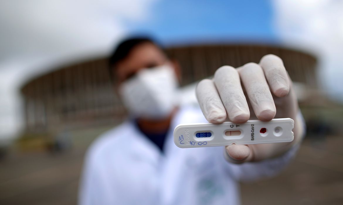 Um profissional médico mostra um teste negativo para o novo coronavírus em frente ao Estádio Mane Garrincha, em meio ao surto da doença por coronavírus (COVID-19), em Brasília, Brasil, 21 de abril de 2020. REUTERS / Ueslei Marcelino