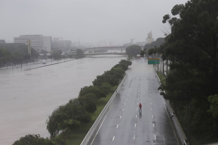 Um homem caminha sobre uma via expressa marginal parcialmente inundada do Tietê após fortes chuvas em São Paulo, Brasil, 10 de fevereiro de 2020. REUTERS / Rahel Patrasso