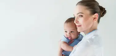 Mulher pediatra segura bebê no colo