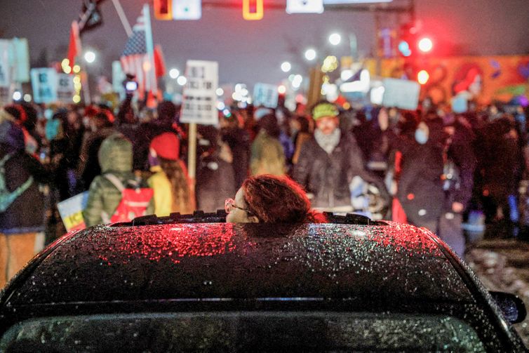 A person looks through a vehicle’s sunroof as people protest against increased immigration enforcement, a day after a U.S. Immigration and Customs Enforcement (ICE) agent fatally shot Renee Nicole Good, in Minneapolis, Minnesota, U.S., January 8, 2026. REUTERS/Brian Snyder TPX IMAGES OF THE DAY
