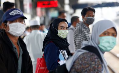 People with surgical masks look on at station Tanah Abang, following the outbreak of the coronavirus in China, in Jakarta