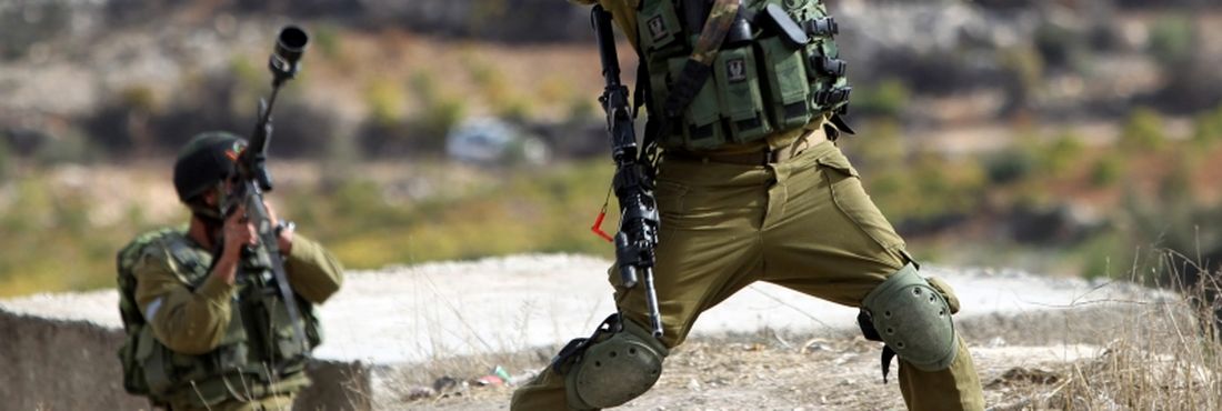 Soldado israelense lança granada contra manifestantes palestinos em Bet Omar, durante protesto contra operação militar israelense na Faixa de Gaza