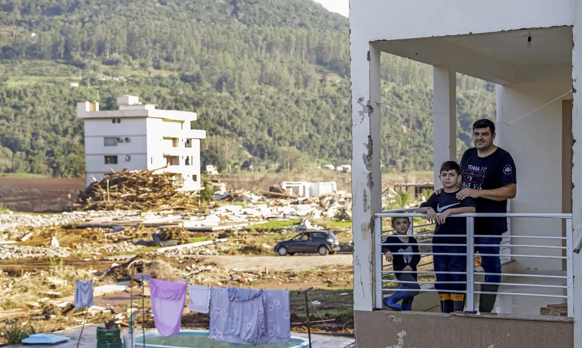 Muçum (RS), 22/06/2024 - Tiago Dalmolin e seus filhos na varanda da sua casa, após enchente que atingiu toda a região. Foto: Bruno Peres/Agência Brasil