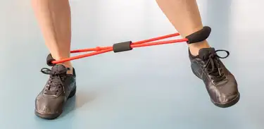 Exercício de pernas usando elásticos