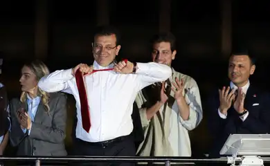 Istanbul Mayor Ekrem Imamoglu, mayoral candidate of the main opposition Republican People's Party (CHP), takes off his tie as he addresses his supporters following the early results in front of the Istanbul Metropolitan Municipality (IBB) in Istanbul, Turkey April 1, 2024. REUTERS/Umit Bektas