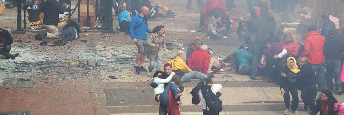 Cidadãos que estavam nas proximidades socorrem os atingidos após explosão de bomba em Boston nesta segunda-feira (15)