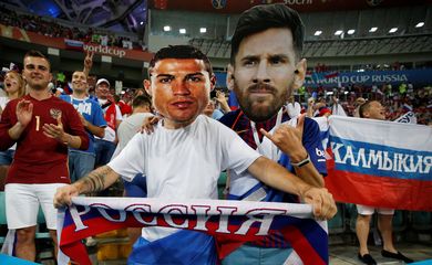 Torcedores russos exibem máscaras de Lionel Messi e Cristiano Ronaldo durante Copa do Mundo, em Sochi, Rússia