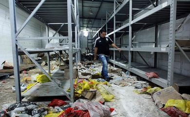 Funcionário caminha em supermercado saqueado em San Cristóbal