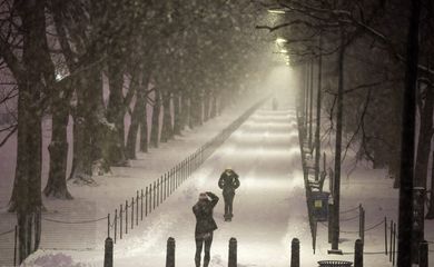 Pedestres param para tirar fotos em meio à tempestade de neve que atinge Washington e outras regiões dos Estados Unidos (Agência Lusa/Direitos Reservados)
